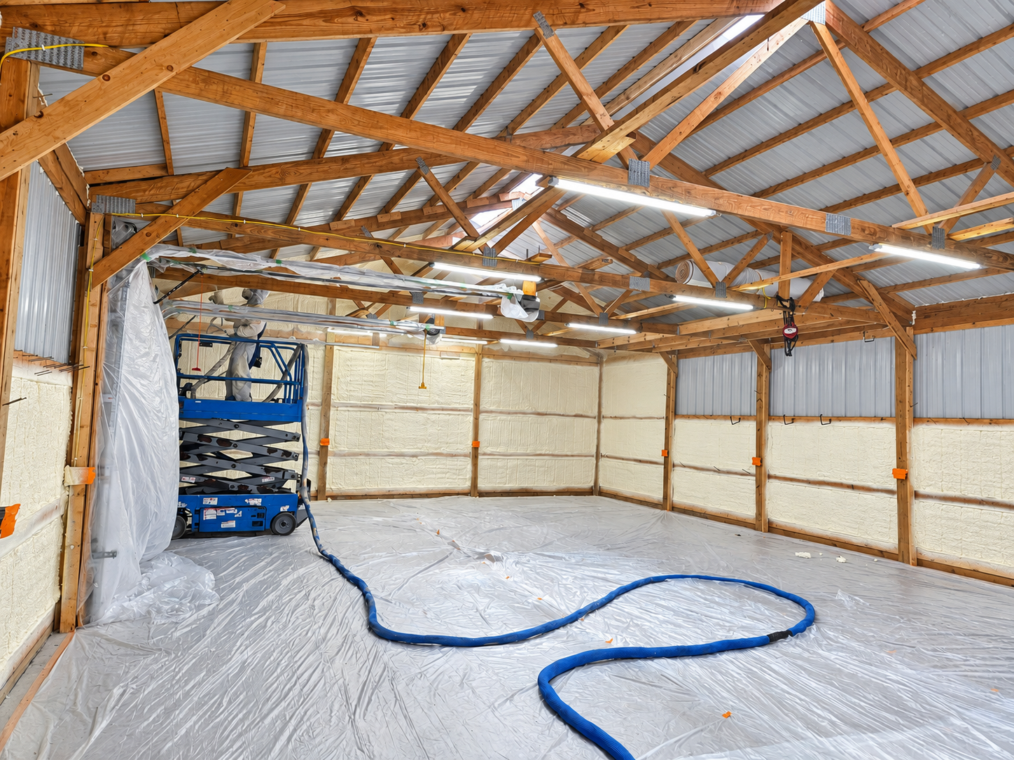 Spray foam insulation being installed in a workshop